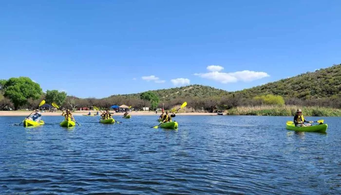 Kayaking tour on Saguaro lake with Butcher Jones Recreation Site in the background. Riverbound Sports Tours.