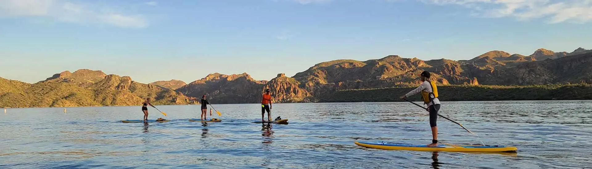 People at paddle boarding lessons on Saguaro Lake at sunset. Riverbound Paddle Company Lessons