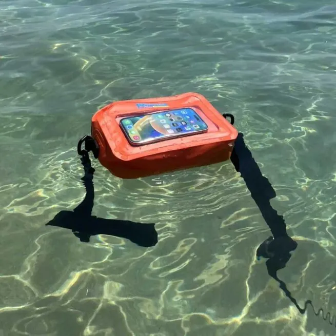 Smartphone in waterproof case floating in clear water.