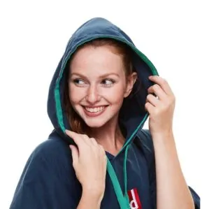 Smiling woman adjusting hood of blue jacket