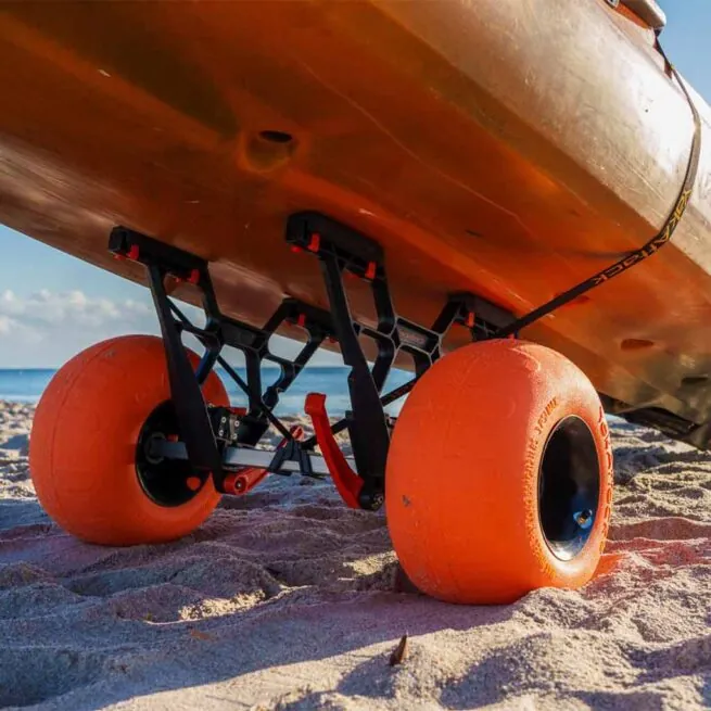 YakAttack Townstow Kayak Cart with orange pneumatic sand tires on the beach with a kayak. Available at Riverbound Sports in Tempe, Arizona.