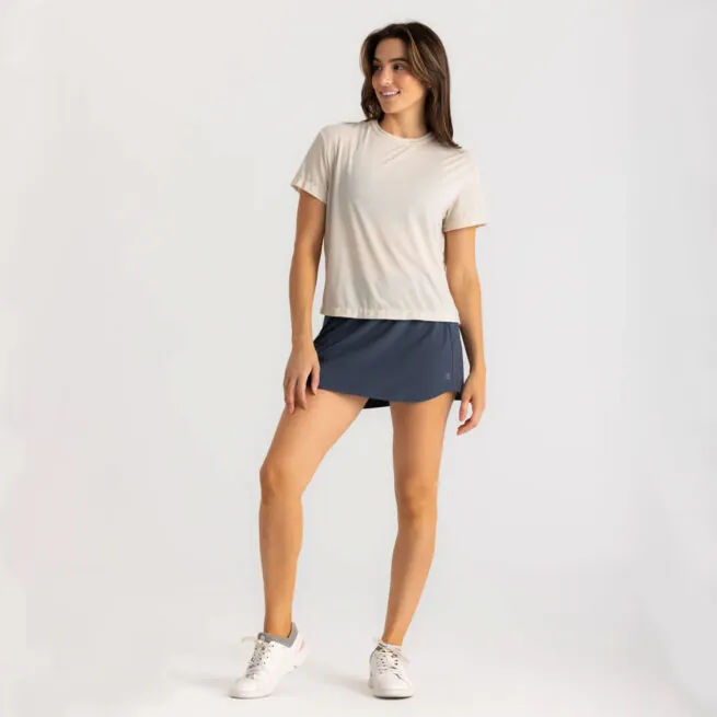 Woman in beige t-shirt and navy shorts posing