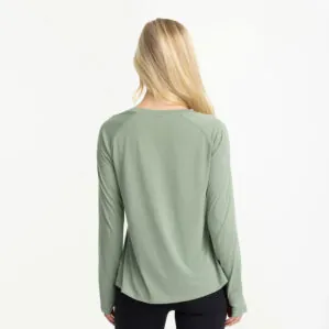 A women in a Free Fly lightweight bamboo long sleeve in palm green color rear view. Available at Riverbound Sports in Tempe, Arizona.