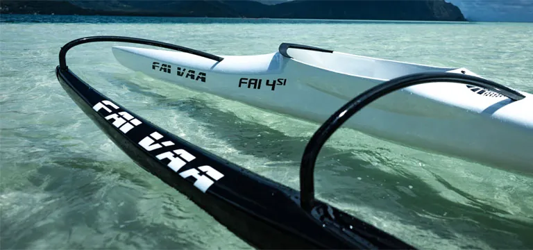 Outrigger canoe floating on clear turquoise water