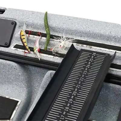 Fishing lures on metallic tackle box with ruler