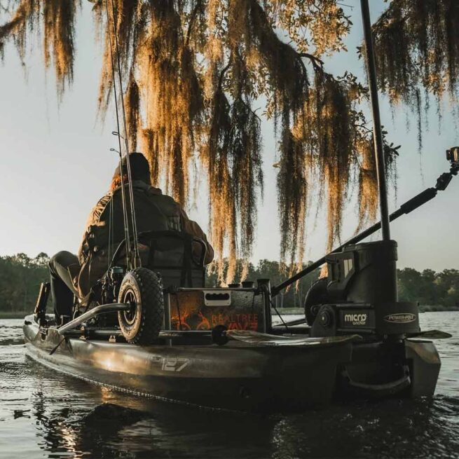 Fisherman in kayak under mossy trees at sunrise showing off the Bonafide Sidekick from Riverbound Sports.