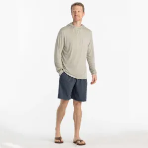 Man in beige hoodie and blue dusk II Free Fly Breeze 8" shorts at Riverbound Sports in Tempe, Arizona.