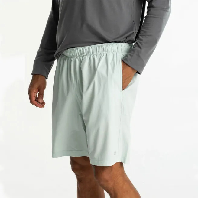 Man in grey hoodie and surf spry color Free Fly Breeze 8" shorts at Riverbound Sports in Tempe, Arizona.