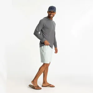 Man in grey hoodie and surf spry color Free Fly Breeze 8" shorts at Riverbound Sports in Tempe, Arizona.